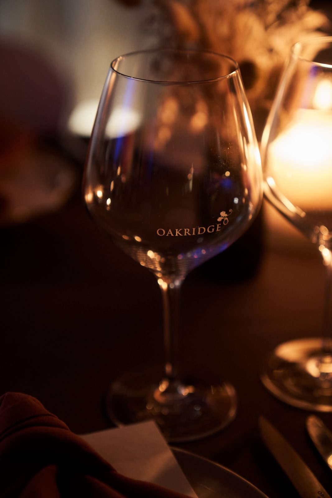 a wine glass is lit by the glow of a candle at Oakridge Wines Restaurant, Yarra Valley, Victoria